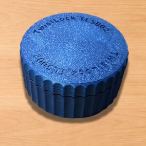 TwistLock metal clay canister with removable lid shown open and closed on a light wood work surface